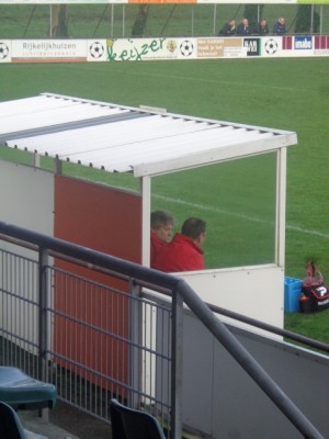 Ronald Mink rustig zittend in de dug-out en soms langs de lijn om zijn team naar voren te dirigeren of scheidsrechter Vlek te bereiken.