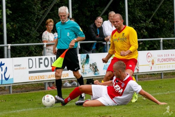 Robin Brasker zet als linksback op tijd een tackle in om Lars van Bommel te beletten er langs te glippen.
